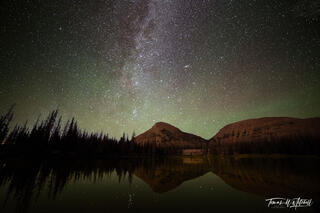 Night sky photograph with mountains and lake