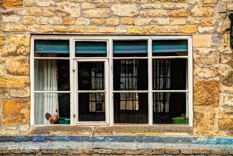 Old window with porcelain rooster, Cotswolds, England 