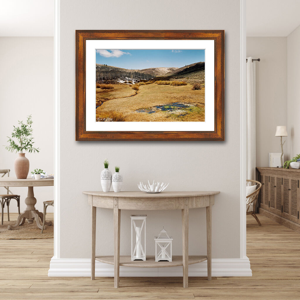framed photograph of mountain pond on home wall