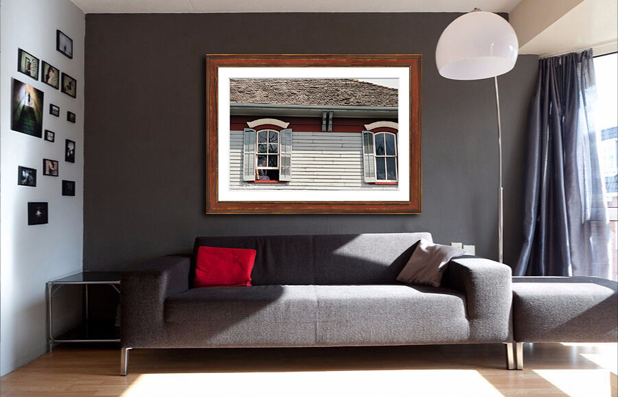 framed photograph of women in window of old building on home wall