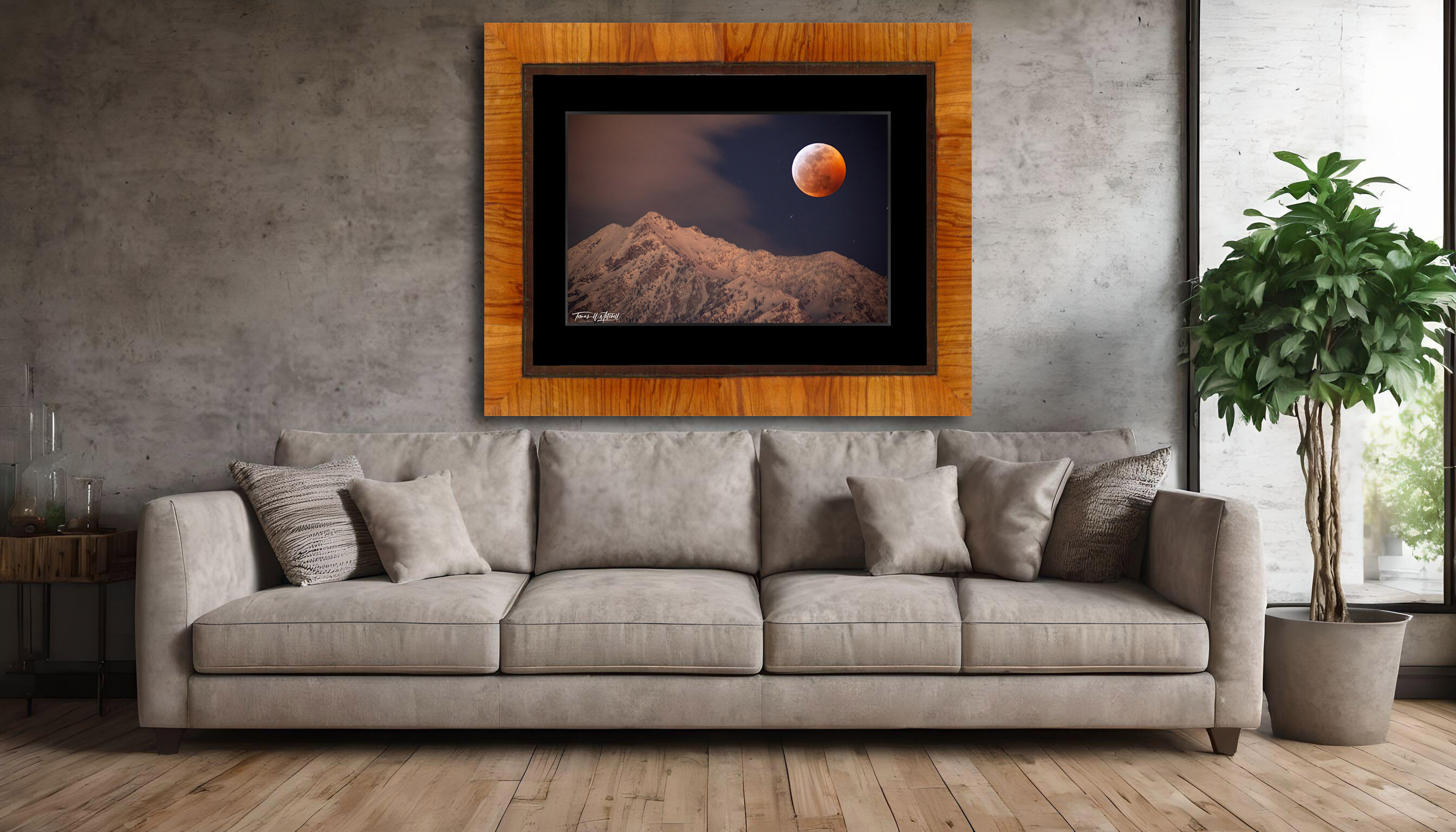 framed photograph of lunar eclipse over snowy mountain on home wall