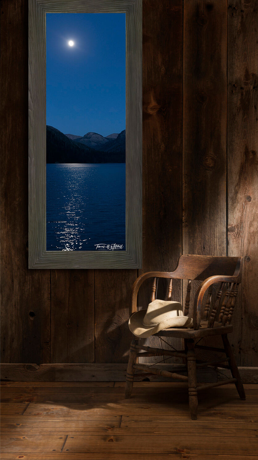 framed photograph of moon rising over mountain lake on wall